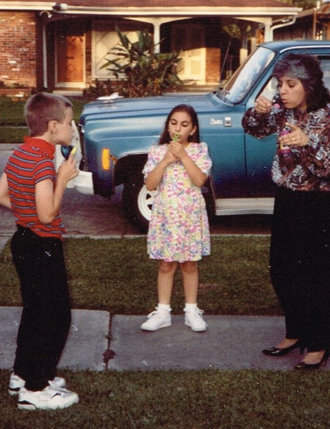 Two children and an adult in the late 1980s blowing bubbles